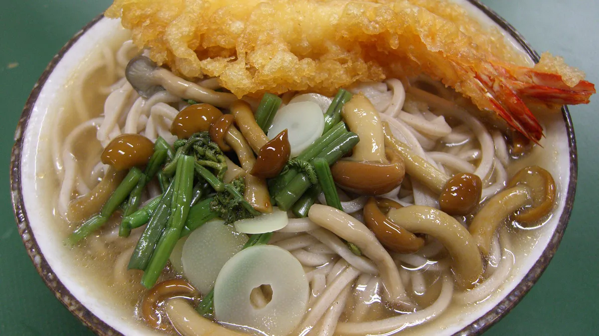 Toshikoshi soba, the long buckwheat noodles eaten on the last night of the year Bowl of toshikoshi soba buckwheat noodles in broth with shrimp tempura, mushrooms and mountain vegetables