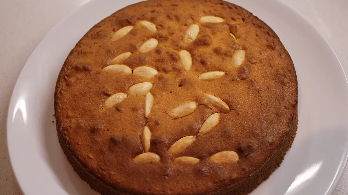 Vasilopita, the coin cake cut at the turn of the year Round Greek vasilopita cake decorated with whole almonds, baked with a hidden coin for the first day of January